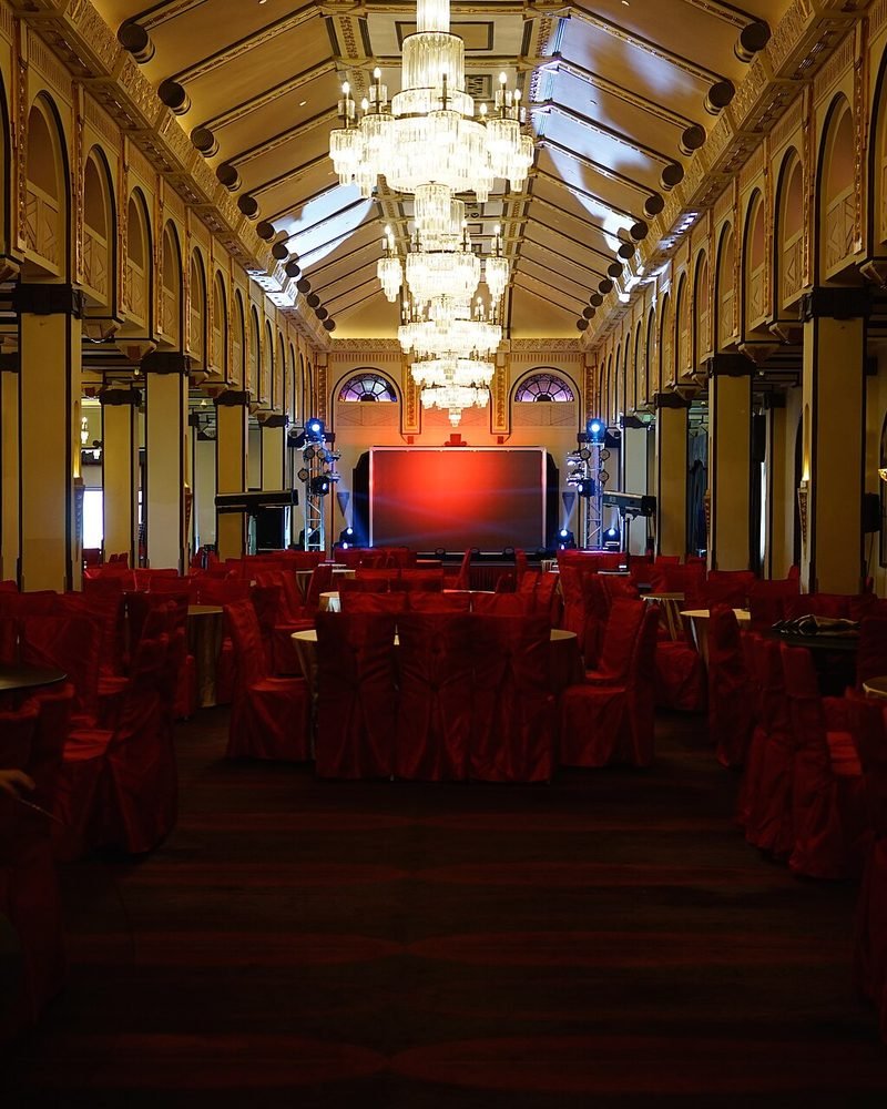 Banquet hall with rows of chairs facing a decorated stage